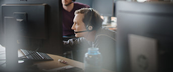 Mann mit Headset am Monitor Mann mit Headset am Monitor